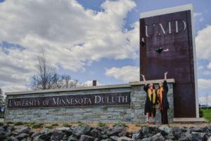 Girls standing in front of UMD sign